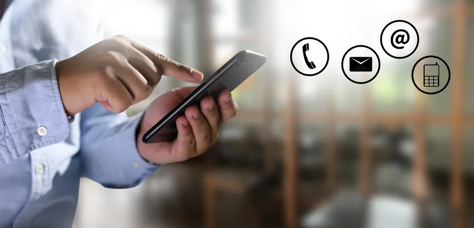 A person using a mobile phone, with contact icons for telephone, email and messaging alongside.
